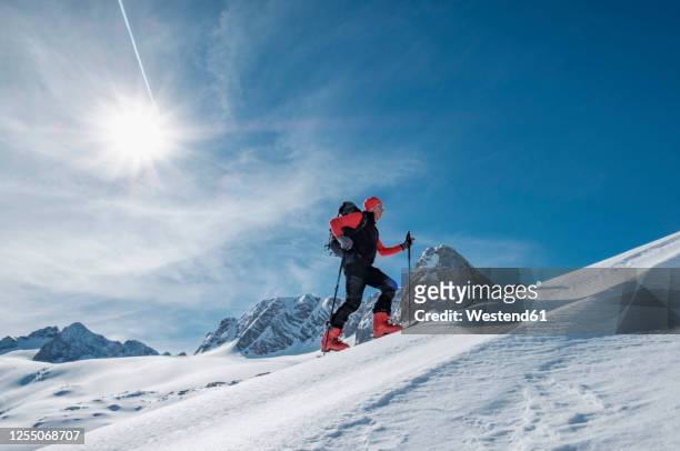 senior man skiing on snow covered dachstein mountain against sky during sunny day, austria - upper austria stock pictures, royalty-free photos & images