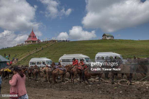 Horses are tied as tourists walk in the Meadow of flowers on May 15, 2023 in Gulmarg, west of Srinagar, Indian administered Kashmir, India. Gulmarg,...
