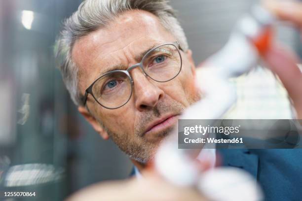 portrait of mature businessman examining industrial product - drehmaschine stock-fotos und bilder