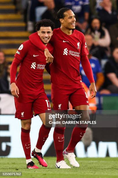 Liverpool's English midfielder Curtis Jones celebrates with Liverpool's Dutch defender Virgil van Dijk after scoring his team first goal during the...