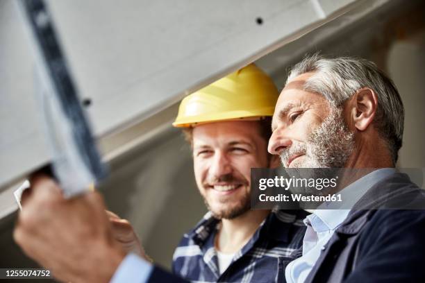 architect and worker measuring window on a construction site - foreman stock pictures, royalty-free photos & images