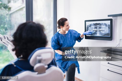 Dentist Explaining Tooth X-Rays To A Patient. Dentist Explaining Tooth X-Rays To A Patient.