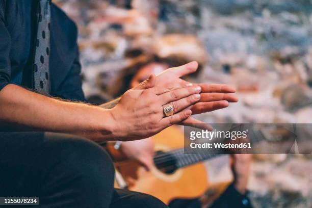 close-up of singer clapping hands while man playing guitar in club - flamencos stock-fotos und bilder