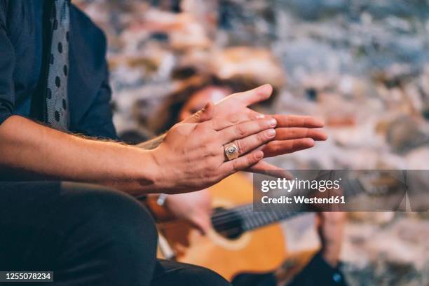 close-up of singer clapping hands while man playing guitar in club - flamenco stock pictures, royalty-free photos & images