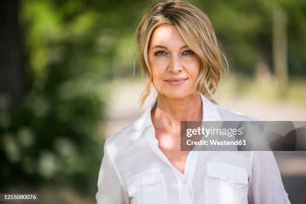 confident mature businesswoman standing outdoors - einzelne frau über 40 stock-fotos und bilder