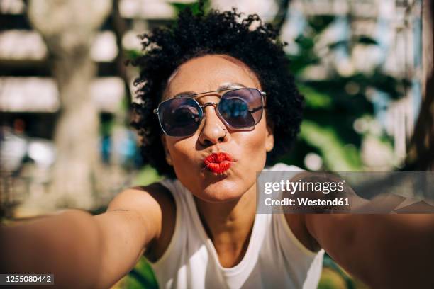 close-up of stylish woman wearing sunglasses puckering lips - woman selfie duck face photos et images de collection
