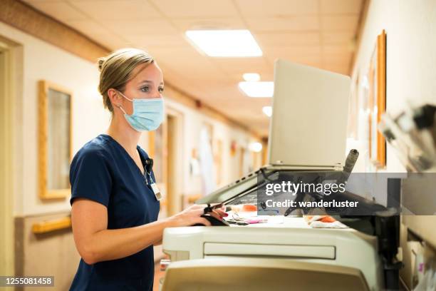 nurse documenting during covid-19 - station stock pictures, royalty-free photos & images