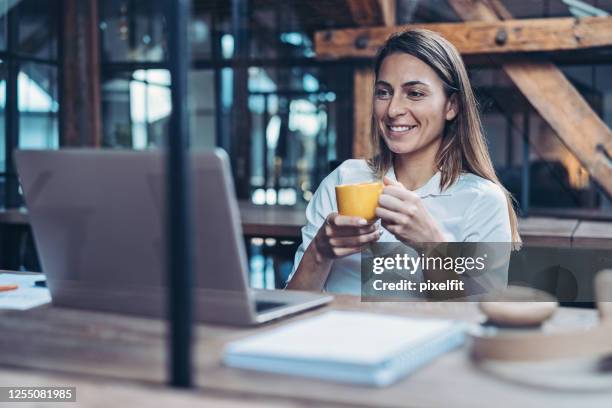 smiling businesswoman in a video call in the office - business meeting coffee stock pictures, royalty-free photos & images