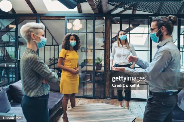 group of entrepreneurs wearing masks and standing at a distance - social distancing business stock pictures, royalty-free photos & images