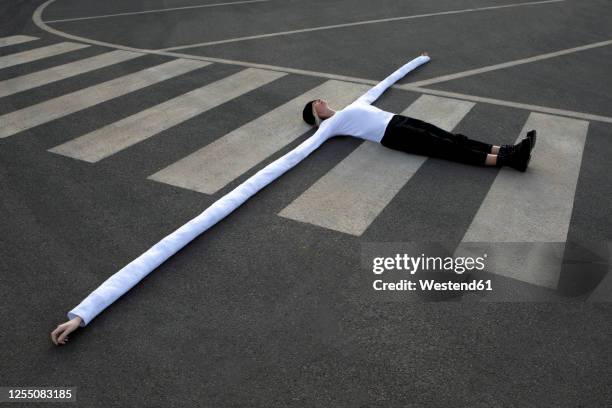 woman with long artificial hands lying on crosswalk - artificial arm stock pictures, royalty-free photos & images