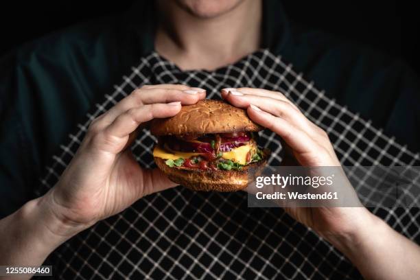 russia, hands of woman holdingready-to-eathamburger with red bell pepper, onions and cheese - hand with bell stockfoto's en -beelden