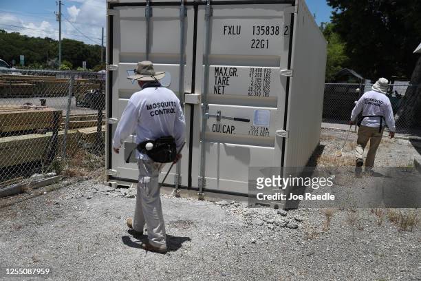 Meredith Kruse and Billy Ryan with the Florida Keys mosquito control department inspect a neighborhood for any mosquitos or areas where they can...
