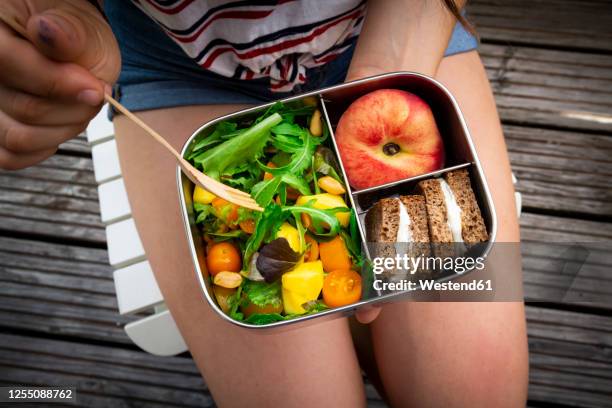 midsection of girl having healthy lunch while sitting on bench - sack lunch stock pictures, royalty-free photos & images