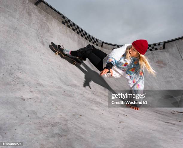 germany, baden-wurttemberg, waiblingen, young woman skateboarding in skate park - women skateboarding stock pictures, royalty-free photos & images