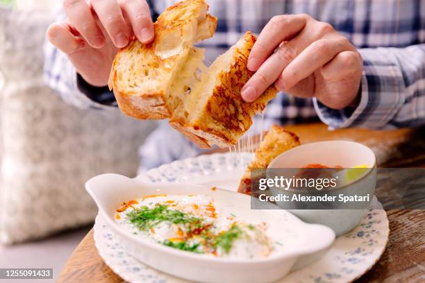 man eating grilled cheese sandwich in a cafe for breakfast - boterham met kaas stockfoto's en -beelden