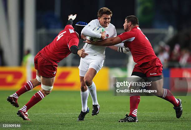 Toby Flood of England is tackled by Ilia Zedginidze and David Kubriashvili of Georgia during the IRB 2011 Rugby World Cup Pool B match between...