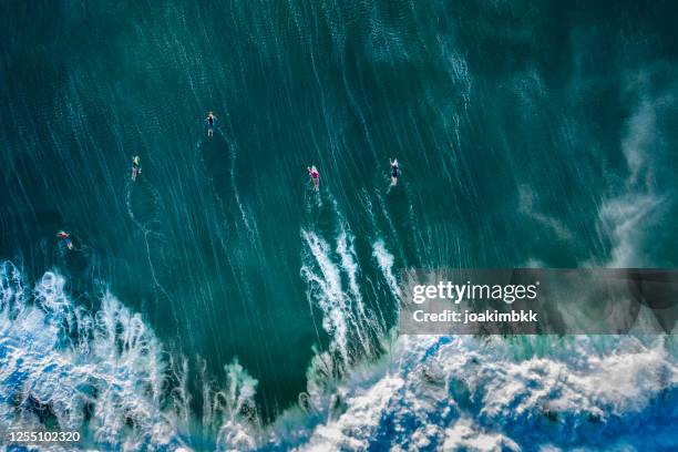 vista de drones de un grupo de surfistas en bali indonesia - surfers fotografías e imágenes de stock
