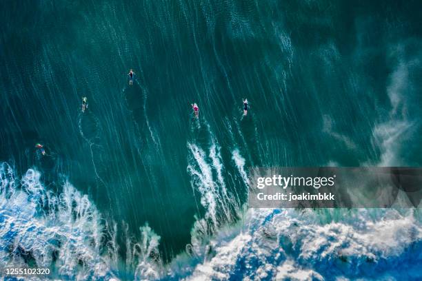 het overzicht van de drone van een groep surfers in bali indonesië - surf stockfoto's en -beelden