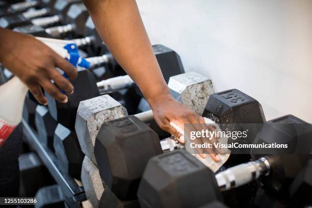 cleaning gym equipment after workout. - gym reopening stock pictures, royalty-free photos & images