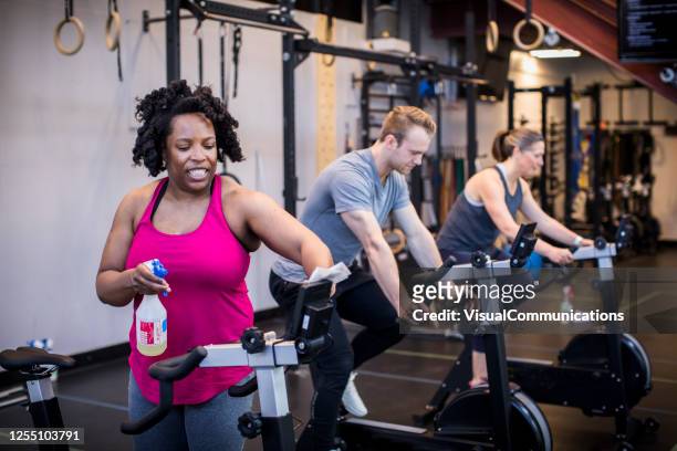 cleaning gym equipment after workout. - cleaning equipment stock pictures, royalty-free photos & images
