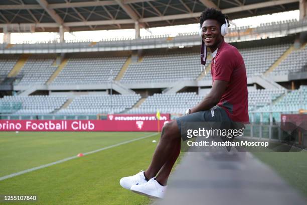 Torino FC's Nigerian defender Temitayo Ola Aina smiles as he listens to music whistle wearing headphones prior to during the Serie A match between...