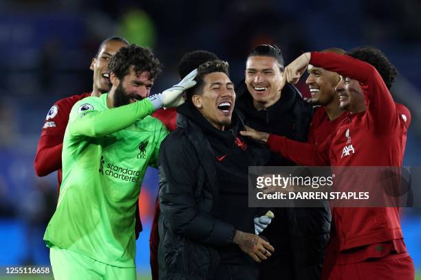 Liverpool's Brazilian striker Roberto Firmino celebrates with teammates at the end of the English Premier League football match between Leicester...