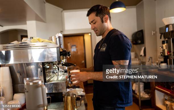 John Jenkins, a native of California who moved to Minnesota, makes a beverage behind the bar at the restaurant he owns in Duluth, Minnesota, on April...