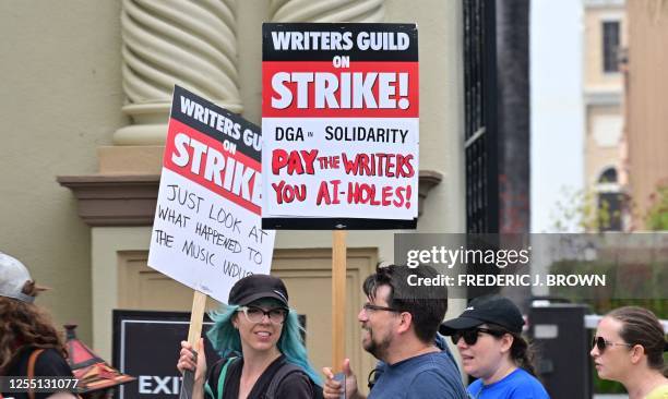 Writers hold signs while picketing in front of Paramount Studios in Los Angeles, California on May 15, 2023 as the strike by the Writers Guild of...