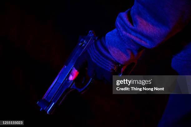 robber holding a gun at abandoned building. criminality concept. - male victim stock pictures, royalty-free photos & images