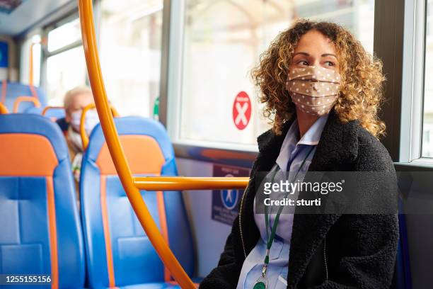 soziale zersagung im bus - essenzielle berufe und dienstleistungen stock-fotos und bilder