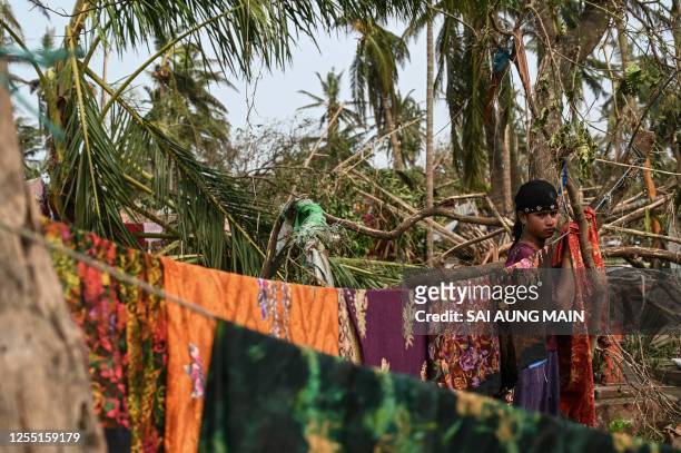 Girl hangs clothes at Basara refugee camp in Sittwe on May 16 after cyclone Mocha made a landfall. The death toll in cyclone-hit Myanmar's Rakhine...