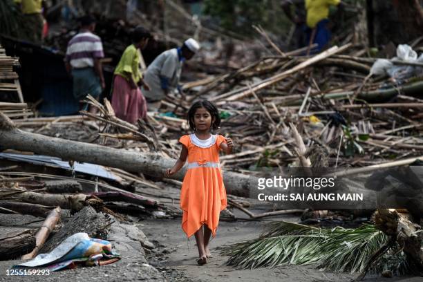 Girl walks past destroyed houses at Basara refugee camp in Sittwe on May 16 after cyclone Mocha made a landfall. The death toll in cyclone-hit...