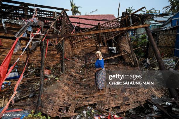 Rohingya woman stands in her destroyed house at Basara refugee camp in Sittwe on May 16 after cyclone Mocha made a landfall. The death toll in...