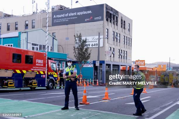 Police stand guard at the site of a fire at the Loafers Lodge hostel building in Wellington on May 16, 2023. A fire ripped through a four-storey...