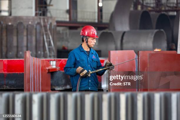 Worker produces building material parts at a factory in Nantong, in China's eastern Jiangsu province on May 16, 2023. / China OUT