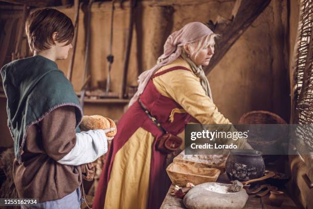 una mujer vikinga individual haciendo tareas diarias en un asentamiento de pueblo vikingo - historia social fotografías e imágenes de stock