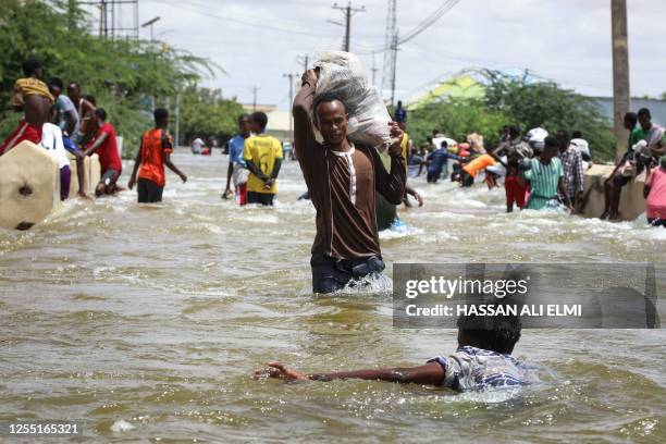 Man carries a sack through floodwater in Beledweyne, central Somalia, on May 14, 2023. Flash flooding in central Somalia has killed 22 people and...