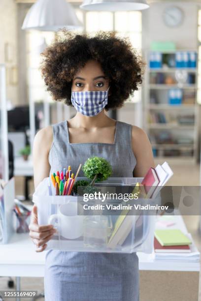 unhappy business woman with surgical medical mask going out with box container, looking at camera and feeling looser. - i quit stock pictures, royalty-free photos & images