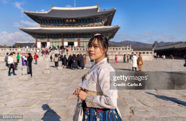 young asian woman traveler in korean national dress or hanbok traveling to gyeongbokgung palace - gyeongbokgung palace stock pictures, royalty-free photos & images