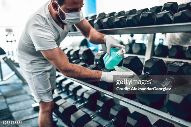 gym disinfection by male with face mask - sports equipment stock pictures, royalty-free photos & images