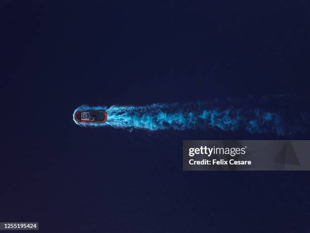 aerial top view of a solo tugboat on the move surrounded by deep blue water. - boat deck stock pictures, royalty-free photos & images