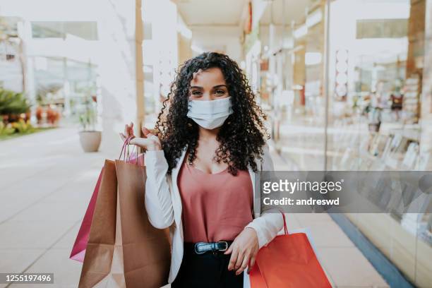 donna che cammina facendo shopping e sorridendo dietro la maschera - centro commerciale foto e immagini stock