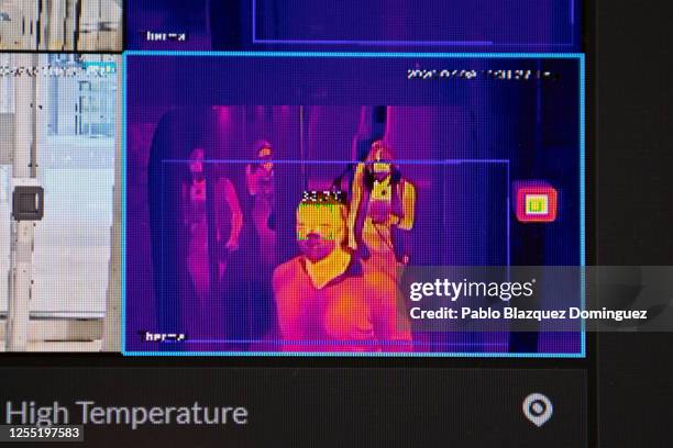 An image from a thermographic camera checks the body temperature of travelers at the health control area at Adolfo Suarez Madrid-Barajas Airport on...