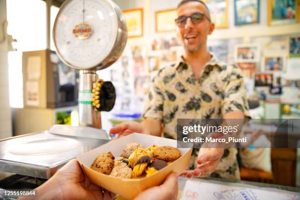 boulangerie - boîte à biscuits de service - man hand holding cookie photos et images de collection