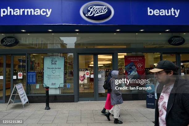 Shoppers in York walk past a Boots pharmacy on July 09, 2020 in York, United Kingdom. Many UK businesses are announcing job losses due to the effects...