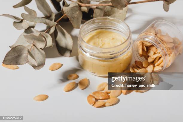 shea butter and argan seeds with dried leaves - shea butter stock pictures, royalty-free photos & images