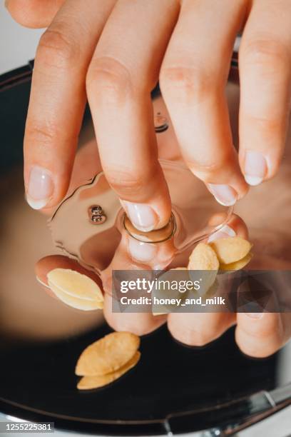 woman dipping her finger in argan oil - argan oil fotografías e imágenes de stock