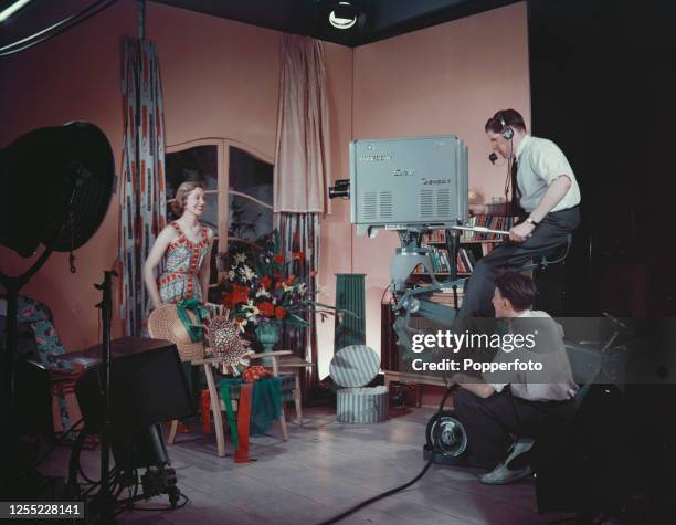 Anne Matthews is filmed by a BBC cameraman operating an experimental Marconi colour television camera for a test transmission in a television studio...