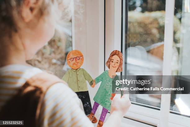 little girl holding cut-out paper people - adoption photos et images de collection