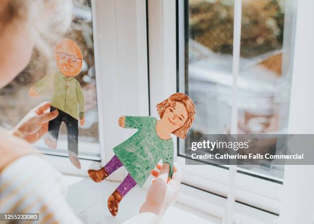 little girl holding cut-out paper people - divorce stockfoto's en -beelden